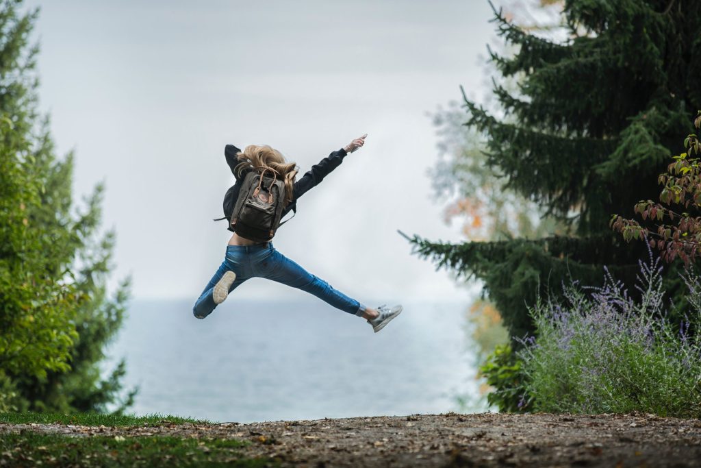 A woman, turned away from the camera, leaping for joy